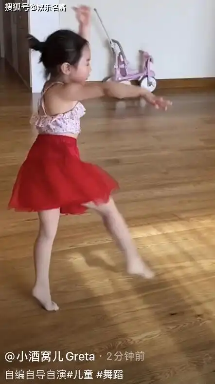 视频中小酒窝扎着丸子头,穿着可爱的碎花吊带背心,搭配红色的蓬蓬裙