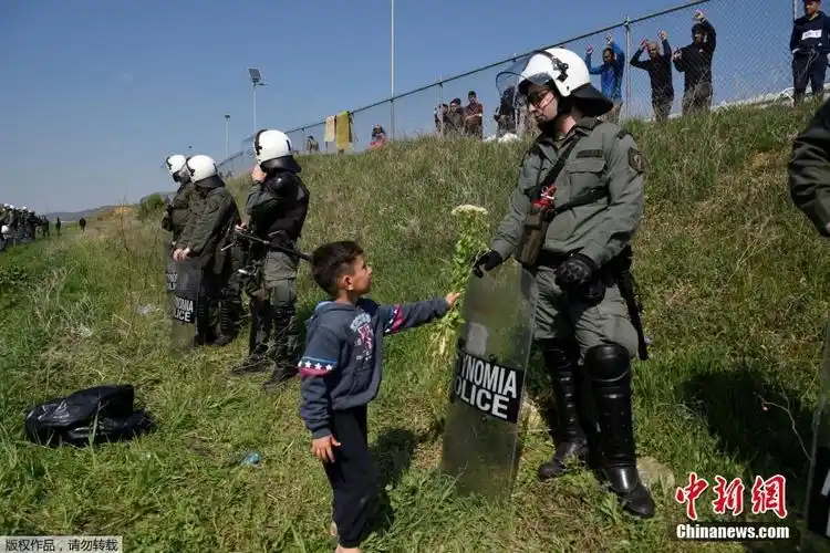 希腊警察阻止难民入境意外收到鲜花