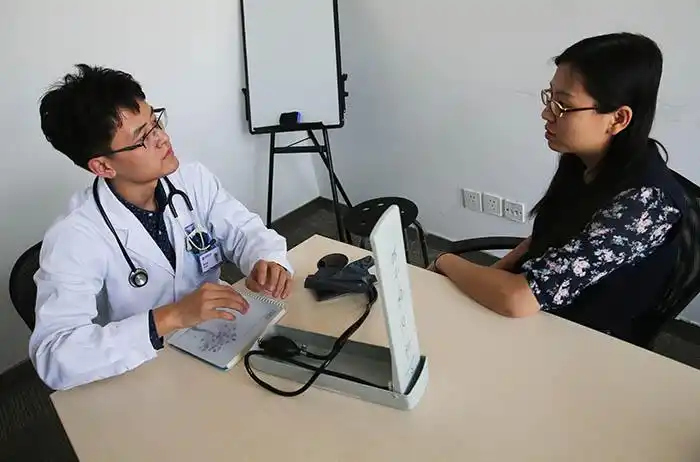 上门为市民问诊的"滴滴医生"刘文龙(左)在询问患者病情(10月19日) )