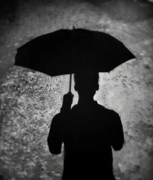 雨中漫步,路灯下撑伞的人.