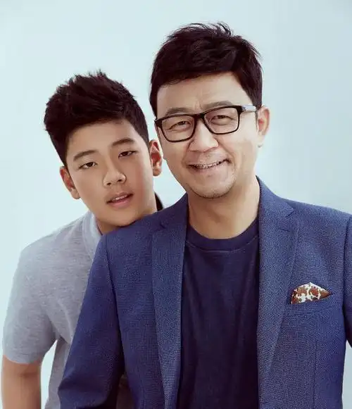 石头站在爸爸身后,微微弯下腰将下巴贴在爸爸肩膀处,父子俩对镜微笑