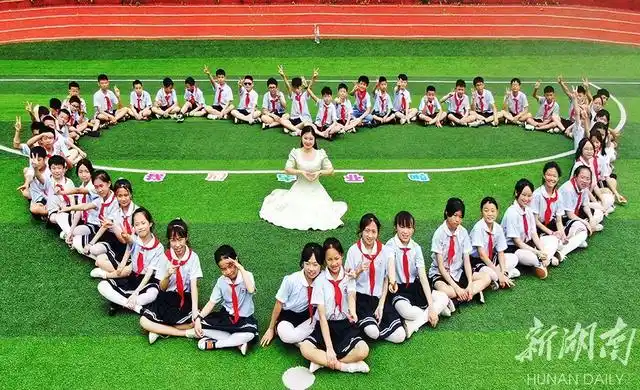 6月22日,嘉禾县群英学校,学生们摆出各种图案拍摄毕业照.