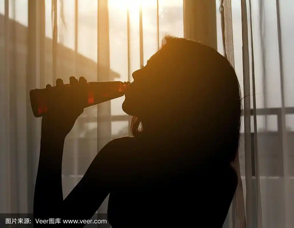 一个女人在房间里喝红酒的剪影