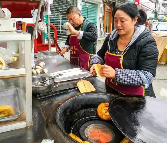 中年夫妻街边摆摊卖锅盔,他们家的锅盔怀远镇一大半的人都吃过