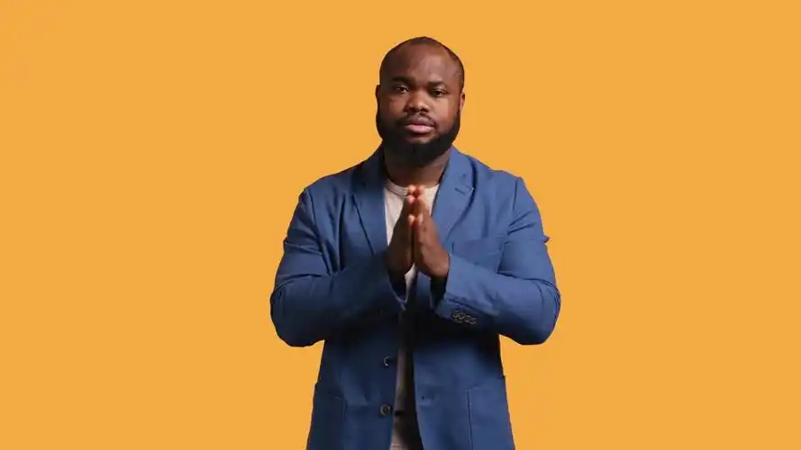 一个男人双手合十,做着乞求的手势,许愿,摄影棚背景