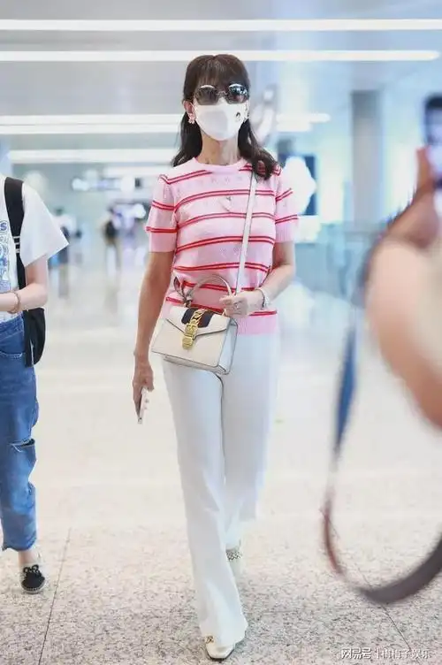 赵雅芝现身机场粉色毛衣配白裤粉嫩穿搭尽显少女心