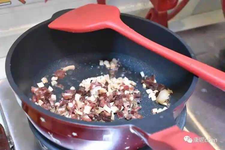 第五步 炒锅放油,用中火炒鱿鱼,腊肠和腊肉,把腊肉炒出香味.