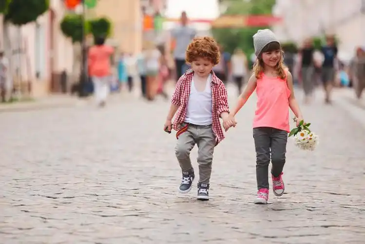 可爱的男孩和女孩走在街上