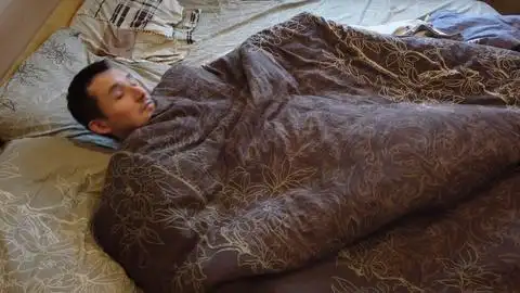 一个人独自在床上睡觉和醒来脸部特写成人头像