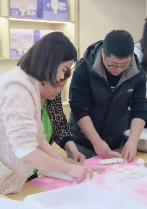 有的朋友手法熟练,包出的饺子形状匀称,令人赞叹;有的则稍显生疏,但在