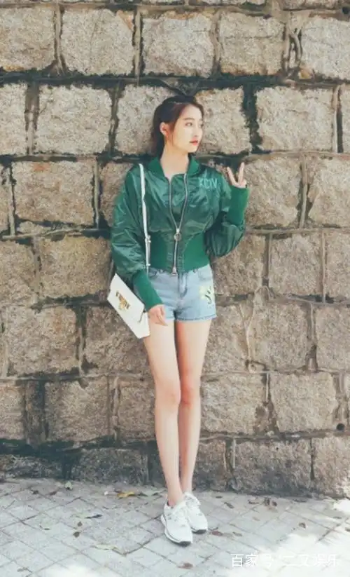 照片中关晓彤穿着牛仔短裤,白色运动鞋,斜靠在围墙上,像不像邻家的大