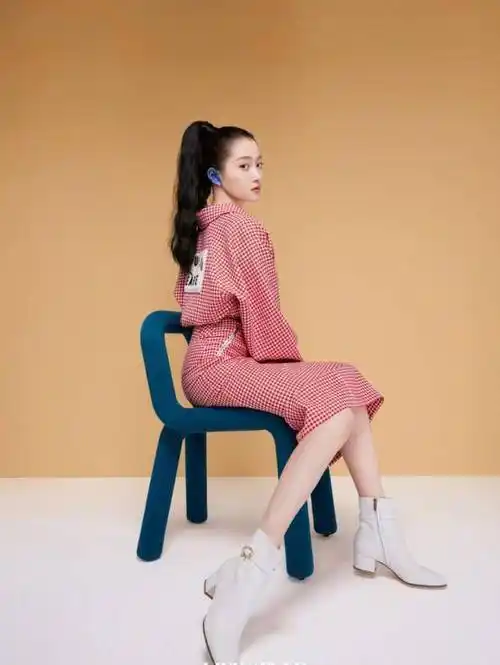 第五张是关晓彤的侧面全身照,她坐在椅子上,粉红色格子上衣加上包臀裙