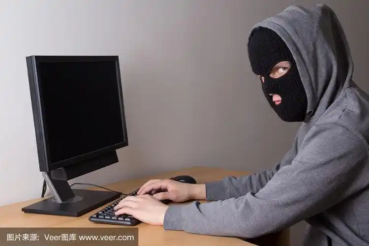 年轻的蒙面黑客在用电脑