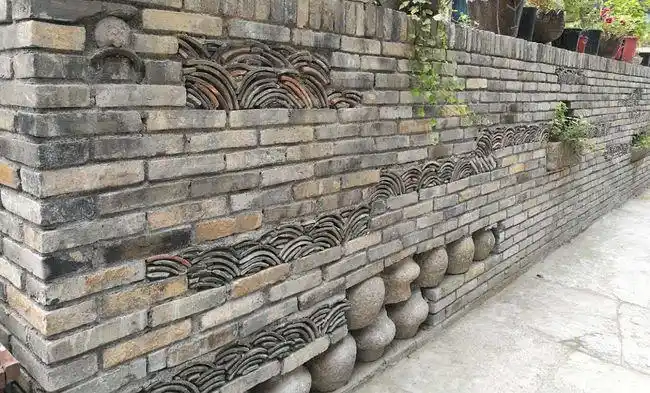 将乡村里常见的瓦片,猪槽,墙砖,石柱础等融于一墙有机整合,留住