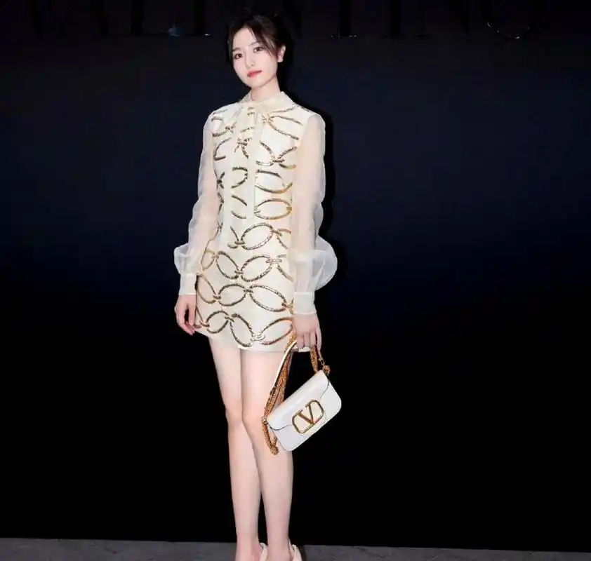 李兰迪难得穿上高跟鞋亮相活动,她身着浅色金丝线礼服十分抢眼.