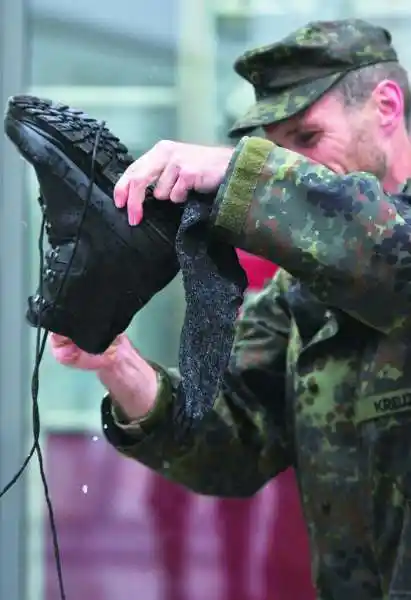 德国军人在救灾过程中抽空倒出靴子里的水