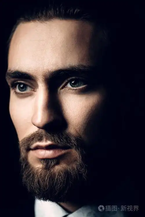 特写肖像的胡子英俊的年轻男子穿着优雅的衣服.