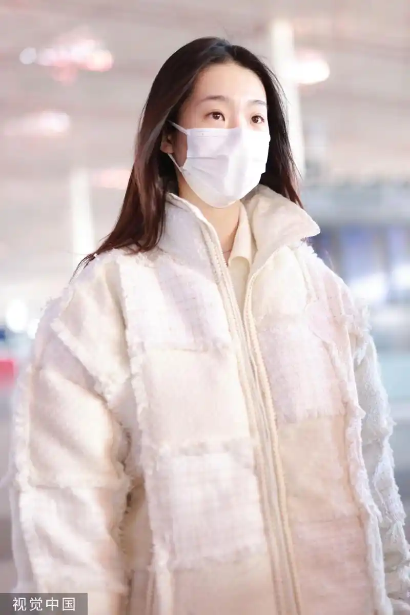 组图:张艺凡白色拼接棉服现身机场 手拿棉花娃娃笑容甜美