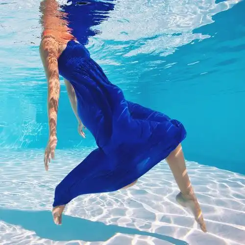 与蓝色的裙子在游泳池水下女人肖像