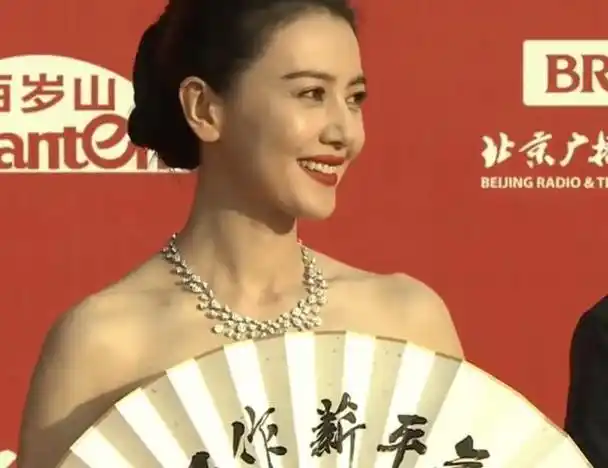 面对镜头,高圆圆皮肤透亮红润,笑容从容大方,立体的骨相和五官连