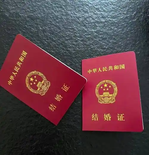 第二张照片里,是两人的结婚证,一共两本,在黑色背景的衬托下十分亮眼.