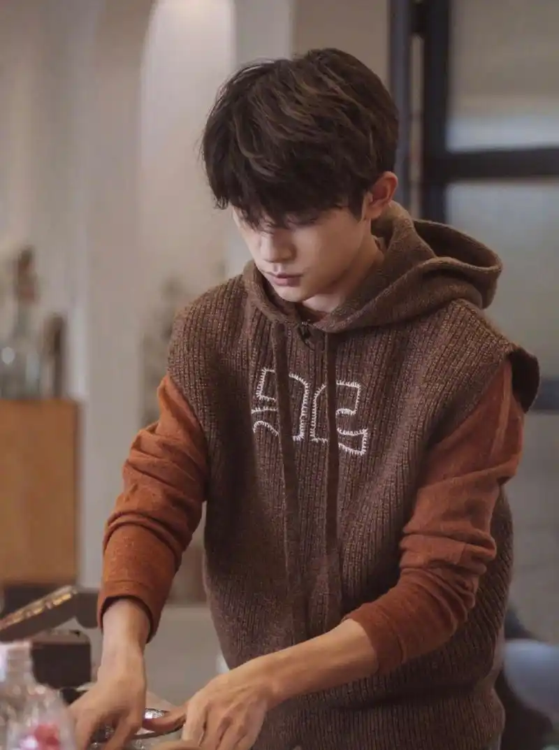 易烊千玺 身着栗色复古连帽马甲,帅气俊朗,文艺范十足.