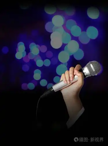 手拿着麦克风对模糊散景背景