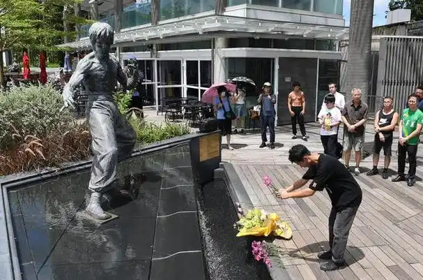 7月20日,影迷向香港星光大道的李小龙铜像献花.新华社记者 陈铎 摄