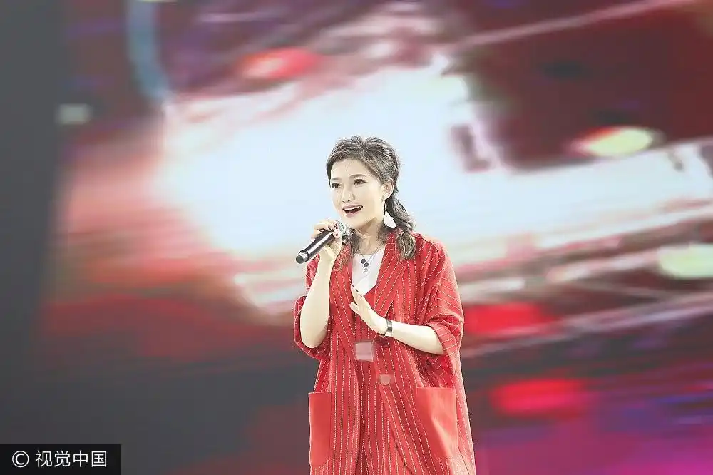 组图:"好声音"丁丁甜美献唱 大红条纹套装秀美腿