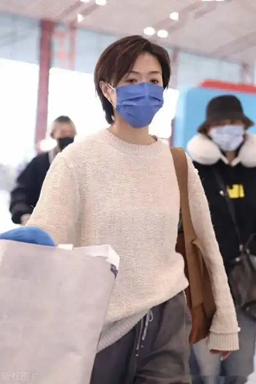 街拍:万茜米白色针织衫 灰色老爹西裤 麂皮单肩包轻松随性_北京_机场