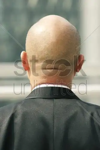 一个西装革履的光头男人的背影