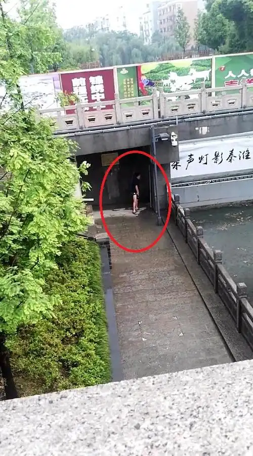 水西门广场工作人员就站在河边"尿尿"