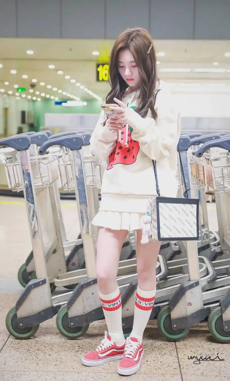 鞠婧祎穿白色卫衣搭配白色百褶短裙现身机场,皮肤白皙面带微笑