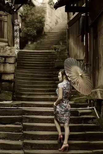 她彷徨在寂寥的雨巷,  撑着油纸伞  像我一样,  像我一样地,  默默行