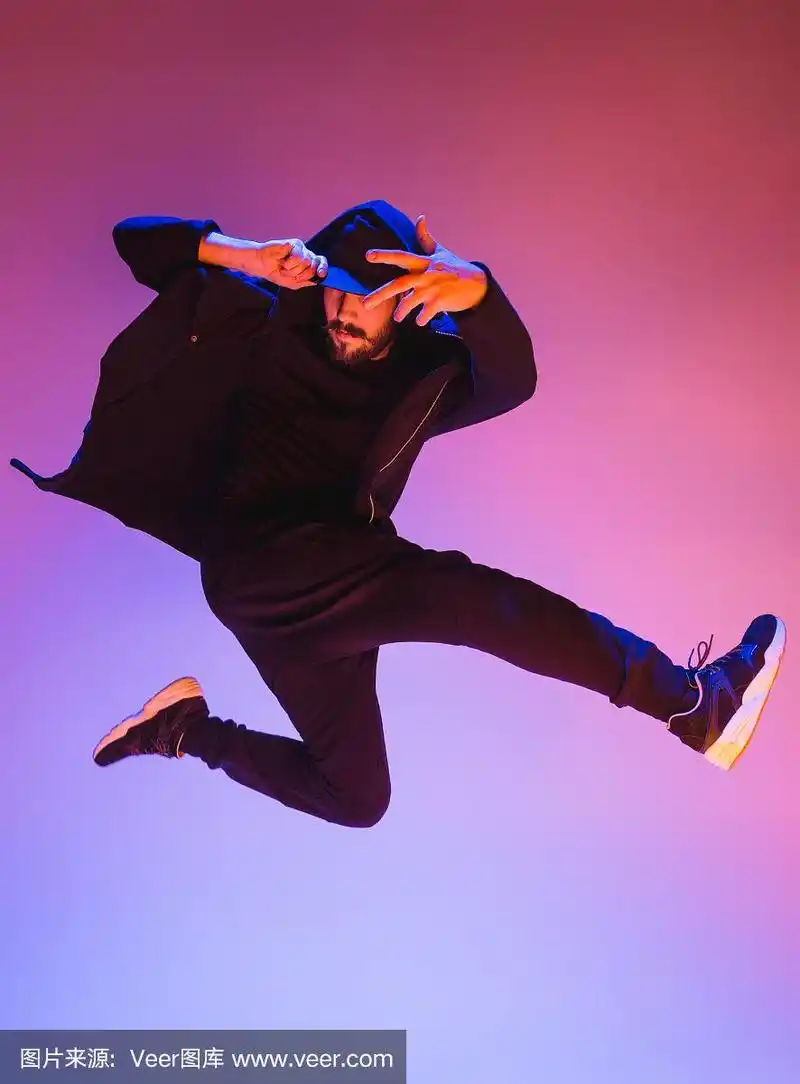 一个街舞男霹雳舞的剪影在多彩的背景上跳舞