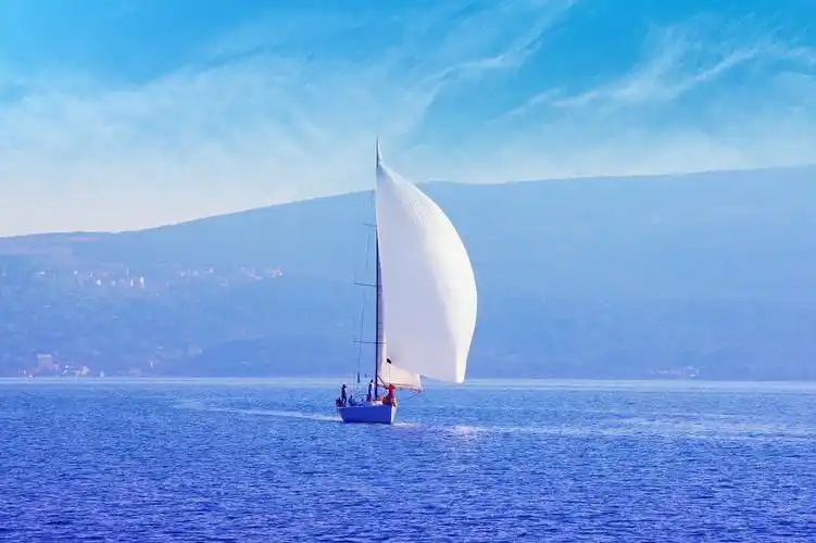 扬帆启航乘风破浪企业拼搏企业精神蓝天白云下的大海和帆船帆船在水面