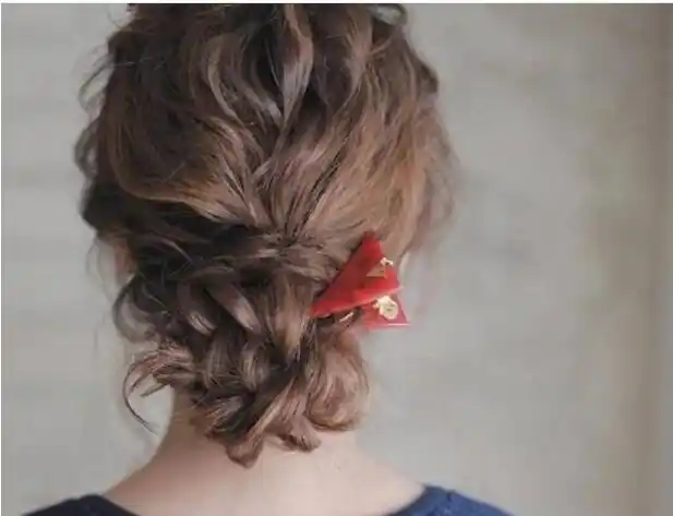 这样的卷发女生扎法就是简单地把头发给盘成了一个低位的盘发发型