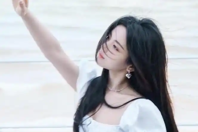杨超越海边大片一袭白色连衣裙爱心耳环点缀发丝飞扬