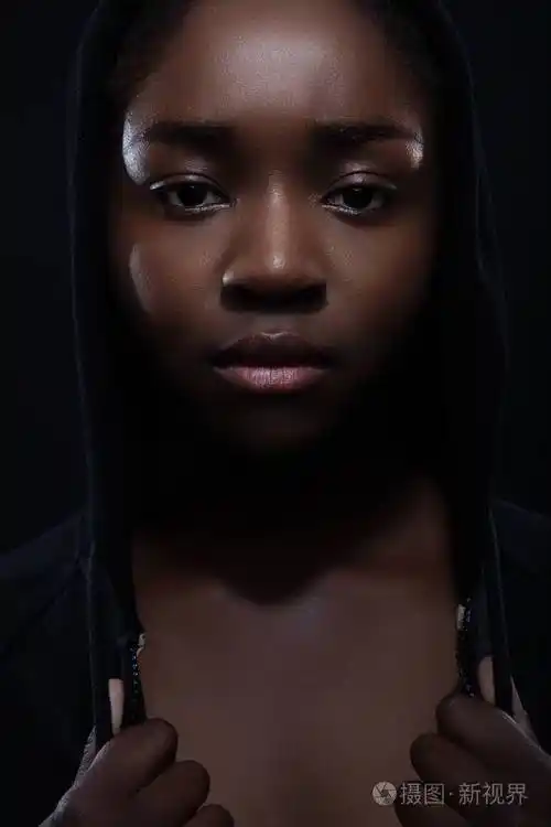 皮肤黝黑态度端庄穿着连帽衫的酷而严肃的女人