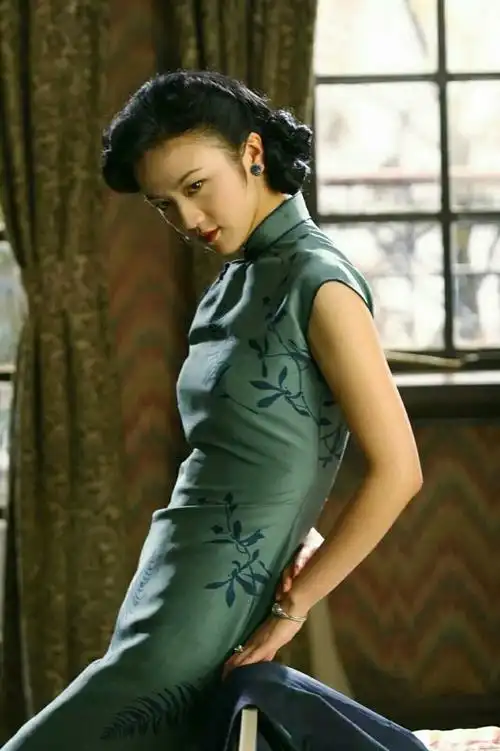 无论靠着椅背,还是随便站着,一身紫色旗袍道尽了忧伤与哀愁.