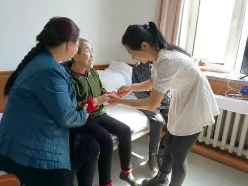 图为:社会爱心人士在乐居养老院献爱心为老人剪指甲.