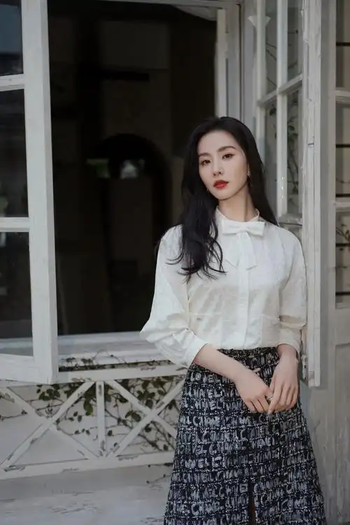图片中刘诗诗身穿提花纯色上衣,领子处点缀蝴蝶结,下身穿黑色半身裙