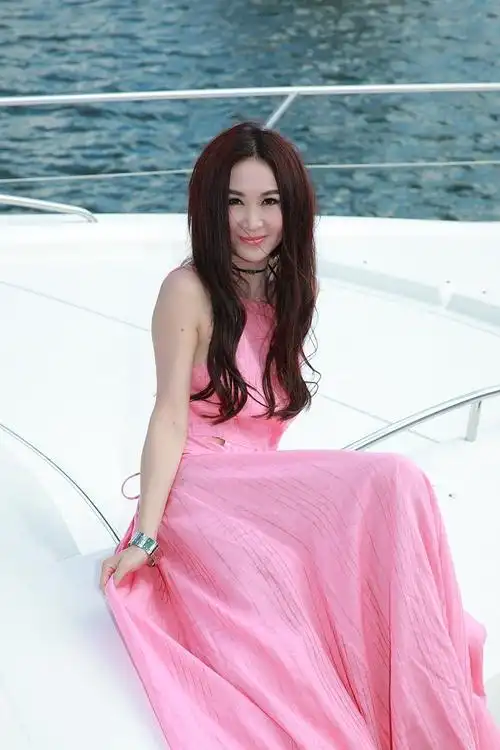 54岁温碧霞穿粉色长裙坐游艇背后镂空大秀身材