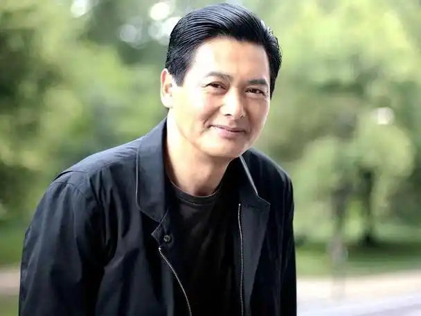 周润发盘腿坐水泥地,皮肤黝黑头发打结老太多,在片场做饭接地气