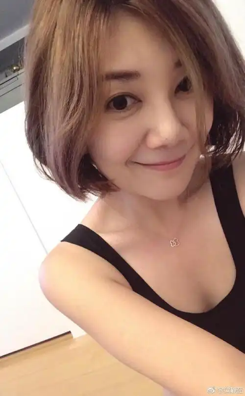 "照片中,梁静茹身穿黑色吊带衣,手臂纤细,一脸素颜,皮肤光滑白皙,笑容