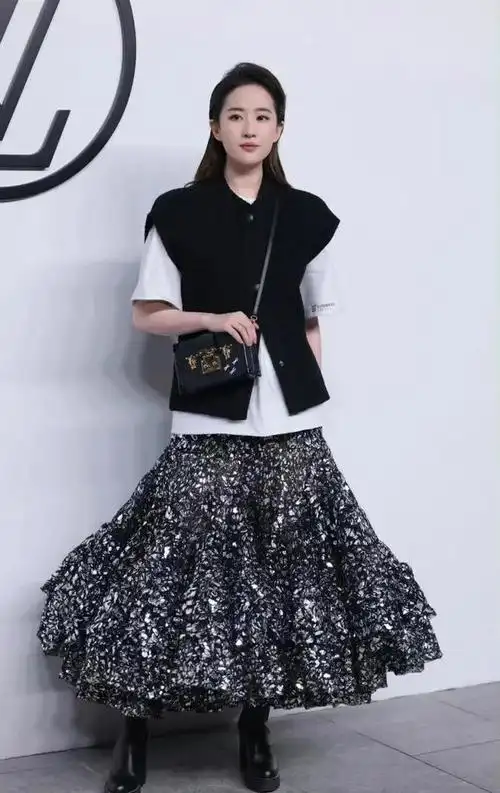 从全身照来看,刘亦菲上装穿的是长款白色t恤外搭一件黑色马甲毛衣!