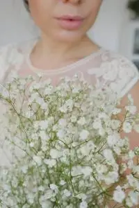 复古风格的图像手捧一束用纸包着的满天星干花白色满天星.