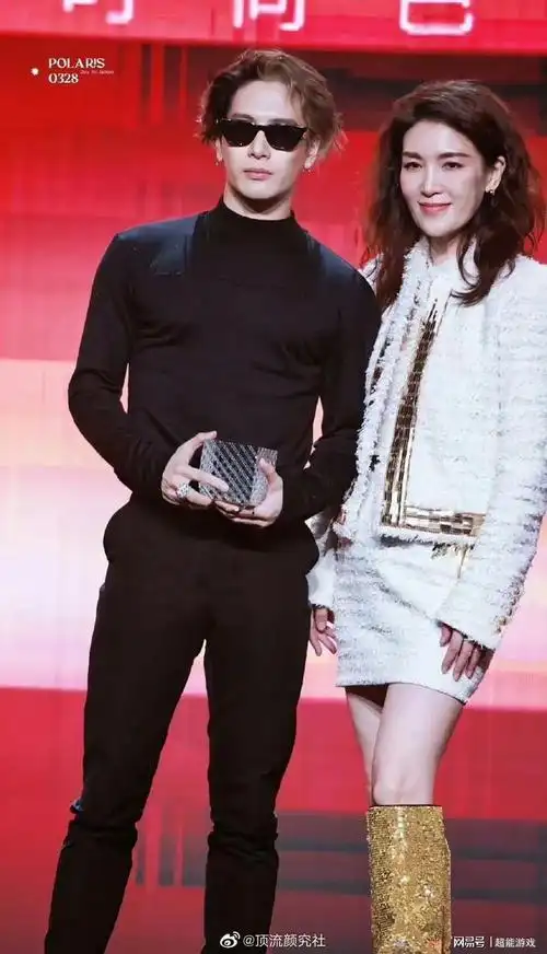 王嘉尔的座位在中间,右手边坐着芭莎杂志社的社长,左手边坐着angela