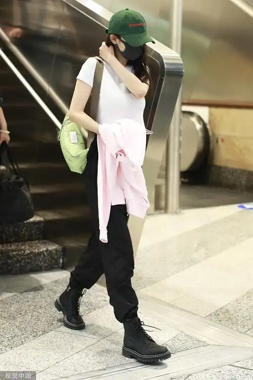 杨幂机场穿露脐装秀纤腰 帽子口罩难挡少女气息