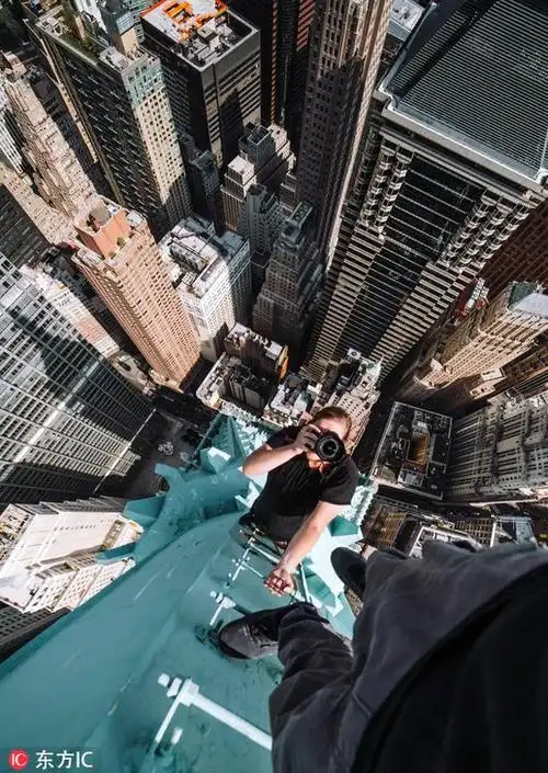 情况下,分别在香港和纽约的摩天大楼楼顶拍摄了刺激又令人惊叹的照片